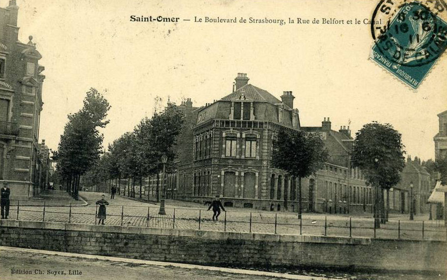 On aperçoit le boulevard de Strasbourg avec ses deux rangées d'arbres sur la gauche et la rue de Belfort sur la droite . Par cette rue on accédait au quartier du Hautpont.